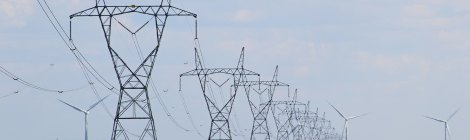 Transmission towers and wind turbines on the field.
