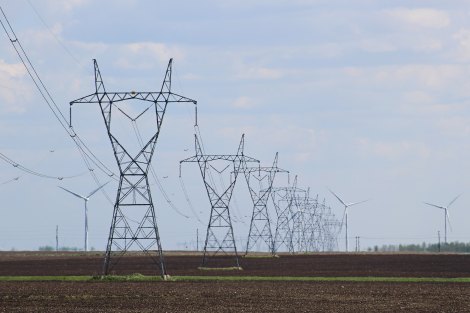 Transmission towers and wind turbines on the field.